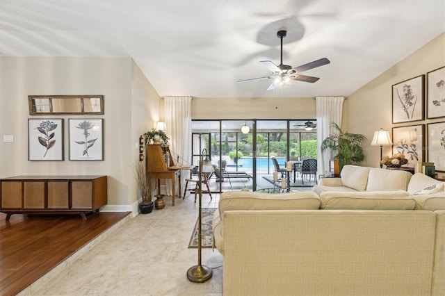 tiled living room with ceiling fan and baseboards