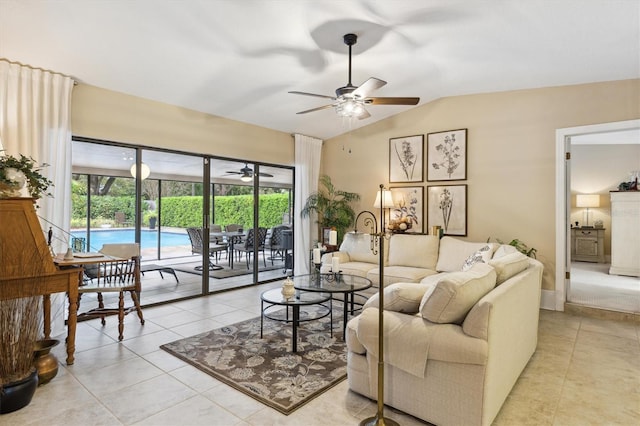 living room featuring a ceiling fan, lofted ceiling, and light tile patterned floors