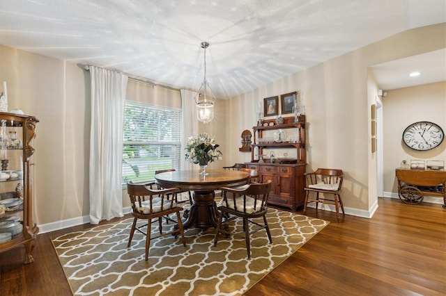 dining space with an inviting chandelier, baseboards, dark wood-type flooring, and recessed lighting