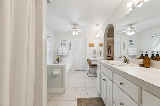 bathroom with a ceiling fan, tile patterned flooring, a garden tub, and vanity