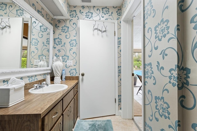 bathroom with wallpapered walls, tile patterned flooring, and vanity