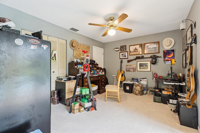 office featuring carpet floors, ceiling fan, and visible vents