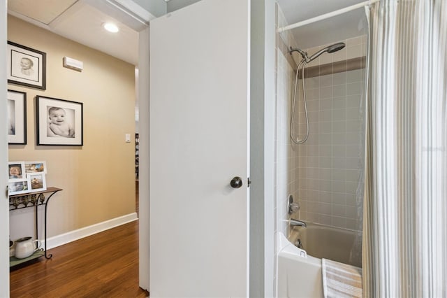 bathroom featuring shower / bathtub combination with curtain, wood finished floors, and baseboards