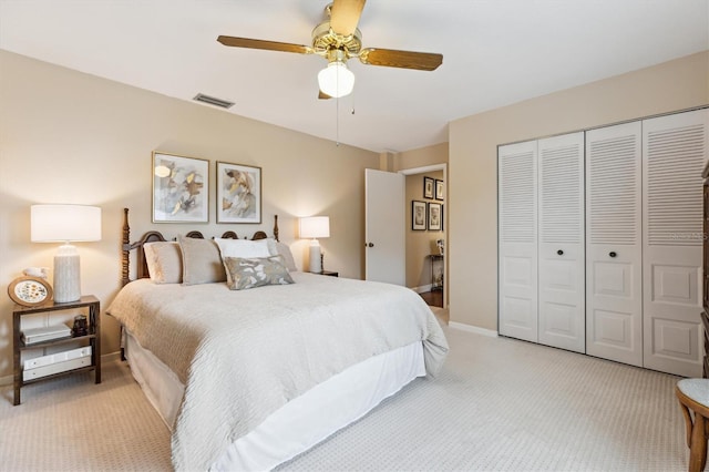 bedroom with light carpet, baseboards, visible vents, and a closet