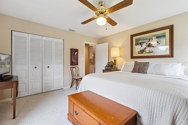 bedroom with a closet, light colored carpet, visible vents, ceiling fan, and baseboards