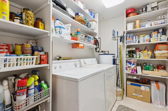 clothes washing area featuring laundry area, water heater, and independent washer and dryer