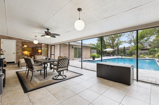 sunroom featuring lofted ceiling and a ceiling fan