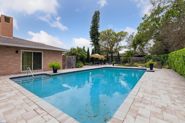 view of swimming pool featuring a patio area, fence, and a fenced in pool