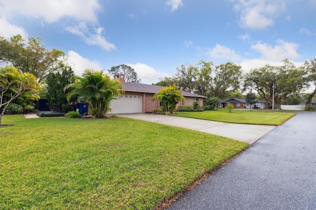 ranch-style home with an attached garage, brick siding, concrete driveway, a front lawn, and a chimney