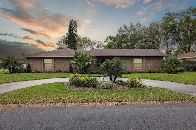 906 Crestview Dr, Auburndale, FL 33823 - view of front facade with curved driveway, a front yard, and brick siding