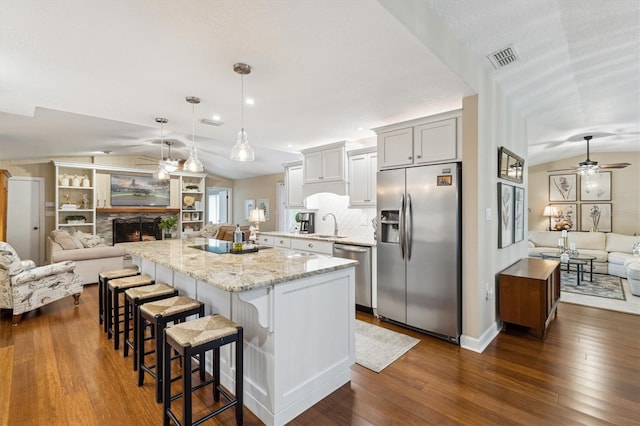 906 Crestview Dr, Auburndale, FL 33823 - kitchen featuring appliances with stainless steel finishes, open floor plan, lofted ceiling, a ceiling fan, and dark wood finished floors