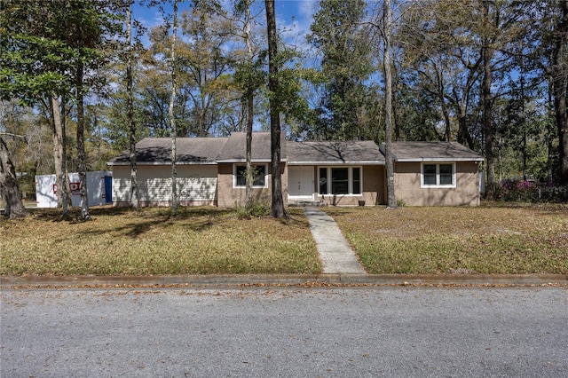 single story home featuring a front lawn