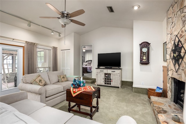 living room featuring ceiling fan, lofted ceiling, a fireplace, visible vents, and carpet