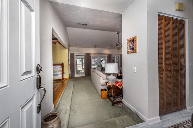 foyer entrance featuring french doors, rail lighting, visible vents, ceiling fan, and baseboards