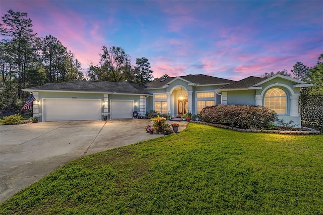 ranch-style house with a garage, stucco siding, concrete driveway, and a front yard