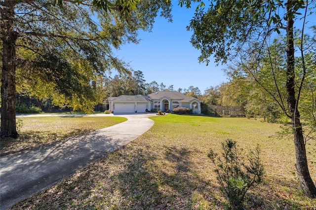 view of front of house featuring a garage, driveway, a front lawn, and fence