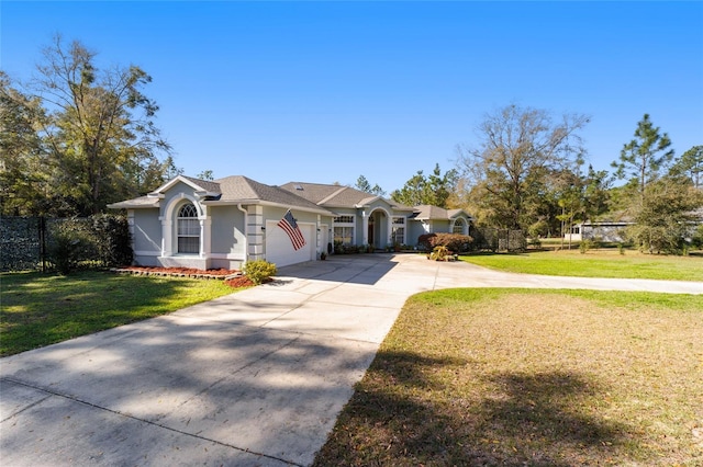 view of front of house with concrete driveway, an attached garage, fence, a front yard, and stucco siding