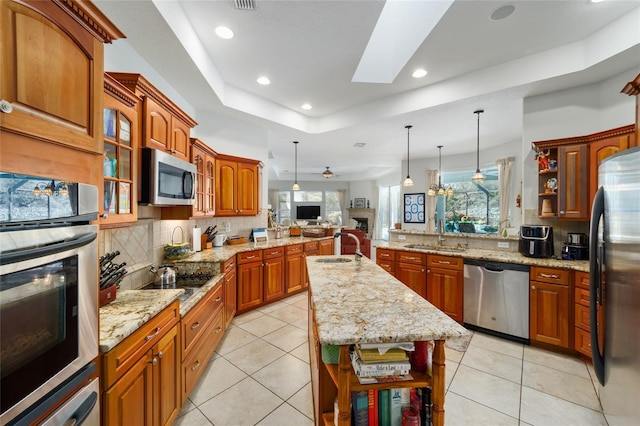 kitchen featuring a peninsula, stainless steel appliances, open shelves, and a sink