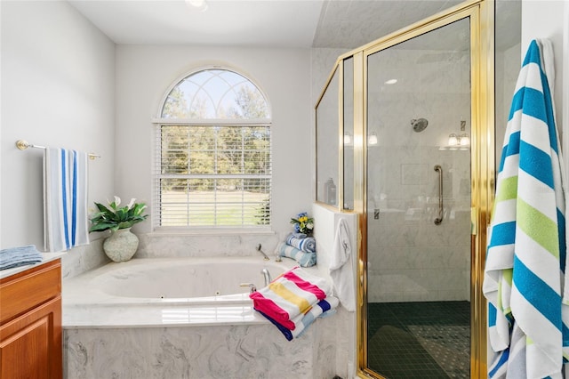 bathroom with a stall shower, plenty of natural light, and a tub with jets