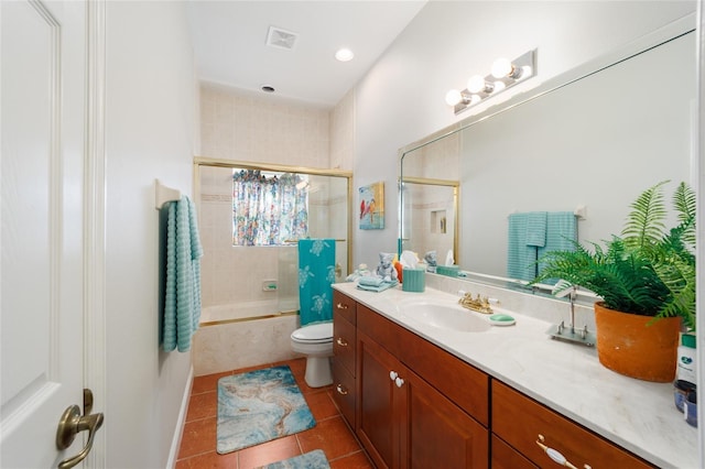 full bath with visible vents, toilet, tiled shower / bath combo, vanity, and tile patterned flooring