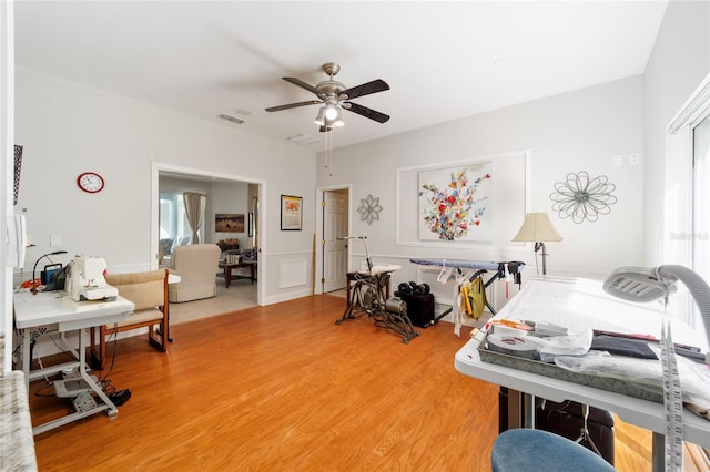 interior space with light wood finished floors, visible vents, and a ceiling fan