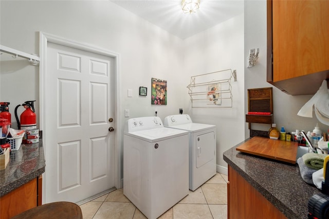 washroom with cabinet space, light tile patterned floors, and separate washer and dryer