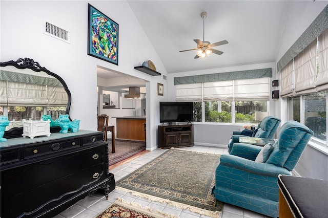 living area with light tile patterned floors, visible vents, baseboards, ceiling fan, and high vaulted ceiling