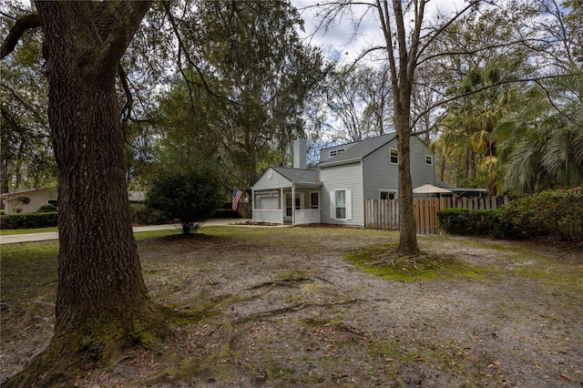 view of front of house featuring fence and a chimney