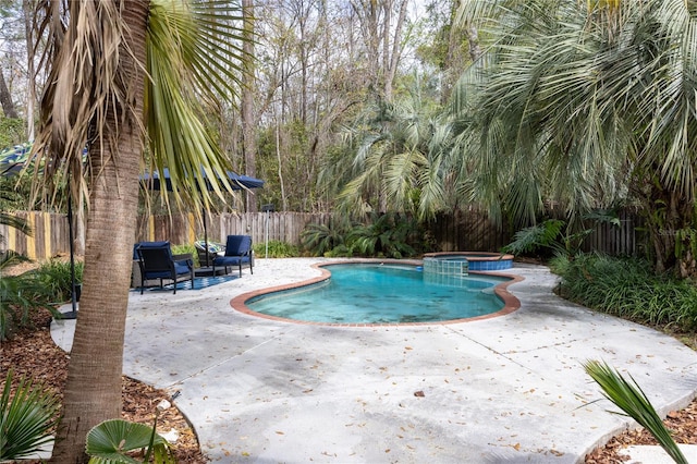 view of pool featuring a pool with connected hot tub, a fenced backyard, and a patio