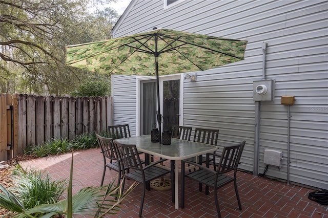 view of patio with outdoor dining area and fence