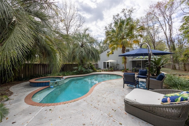 view of swimming pool with a patio area, fence, and a pool with connected hot tub