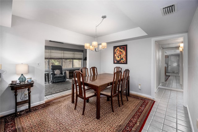 dining space featuring baseboards, visible vents, a chandelier, and light tile patterned flooring