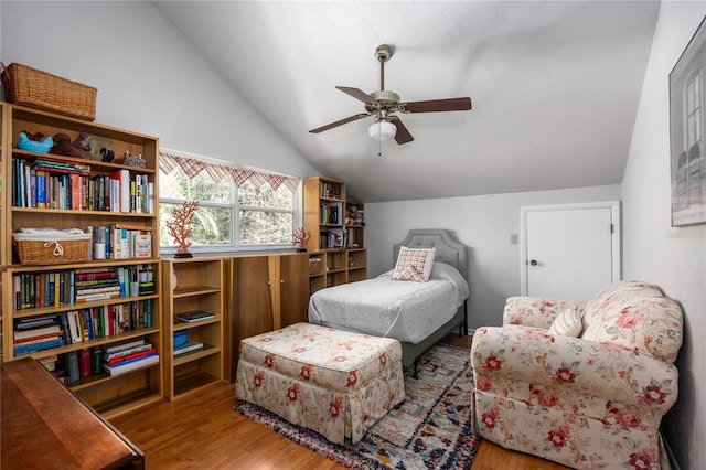 bedroom featuring a ceiling fan, vaulted ceiling, and wood finished floors