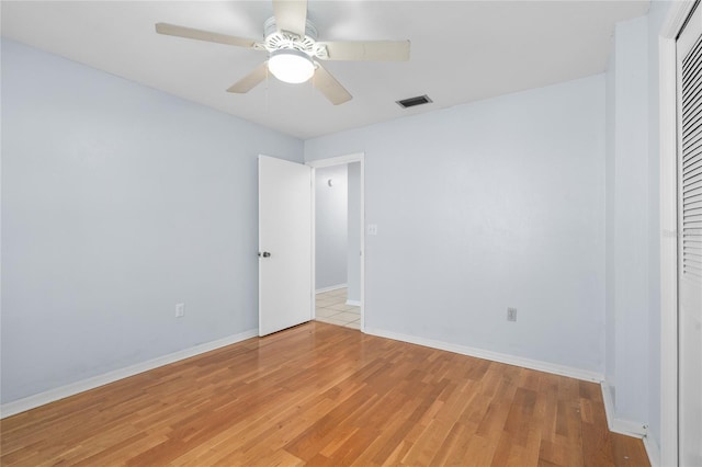 unfurnished bedroom featuring baseboards, a ceiling fan, visible vents, and light wood-style floors