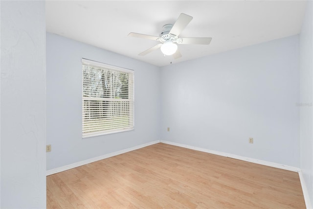 empty room with baseboards, a ceiling fan, and wood finished floors