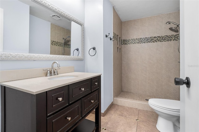 bathroom featuring visible vents, tiled shower, toilet, tile patterned floors, and vanity