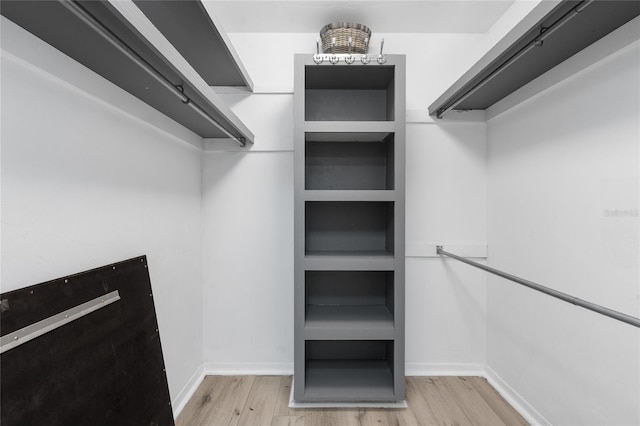 walk in closet with wood finished floors