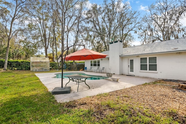 view of pool with an exterior structure, a lawn, a patio area, a fenced backyard, and an outdoor structure