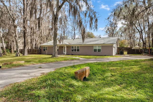 single story home with driveway, fence, a front lawn, and brick siding