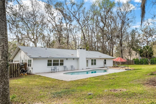 back of property with a yard, a chimney, a patio area, and a fenced backyard