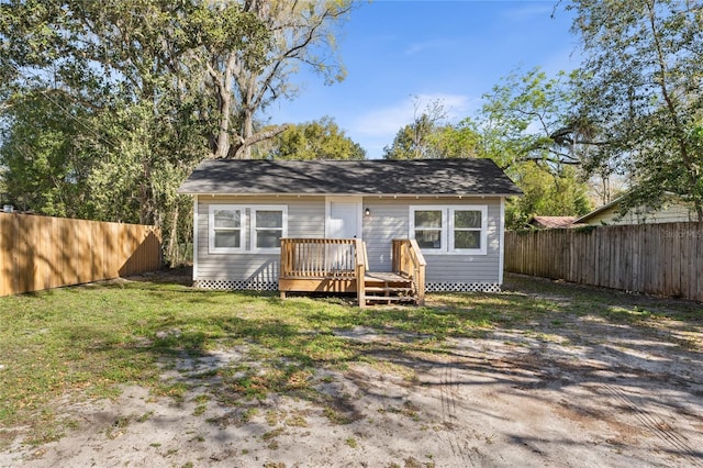 view of front of house featuring a front lawn, a fenced backyard, and a wooden deck