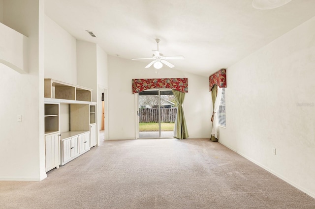 empty room with baseboards, high vaulted ceiling, a ceiling fan, and light colored carpet