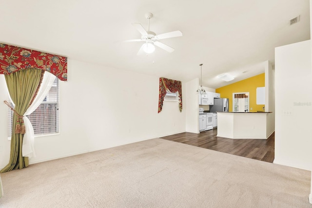 living area with a ceiling fan, dark colored carpet, visible vents, and lofted ceiling