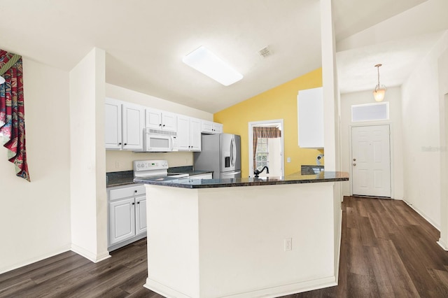 kitchen with white appliances, visible vents, dark wood finished floors, a peninsula, and white cabinetry