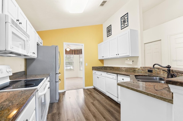 kitchen with white appliances, a sink, visible vents, and white cabinetry