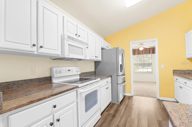 kitchen with lofted ceiling, light wood-style floors, white cabinets, white appliances, and baseboards