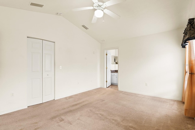 unfurnished bedroom with a ceiling fan, lofted ceiling, visible vents, and light carpet