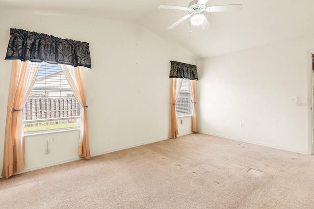 carpeted empty room featuring lofted ceiling, ceiling fan, and baseboards