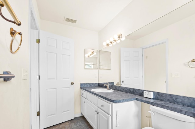 bathroom with visible vents, vanity, and toilet