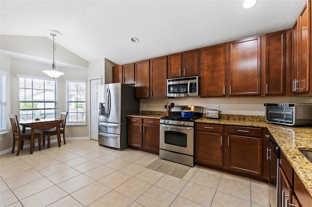 kitchen featuring appliances with stainless steel finishes, a toaster, light tile patterned floors, vaulted ceiling, and hanging light fixtures